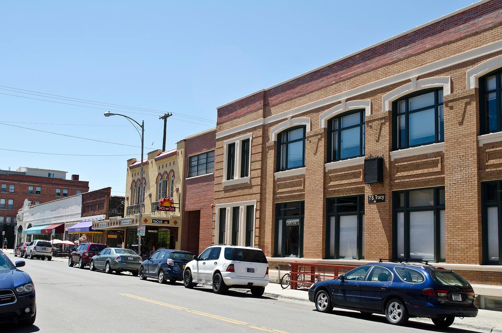 Downtown Bozeman, Montana, with brick storefronts lining South Tracy Avenue on a sunny summer day
