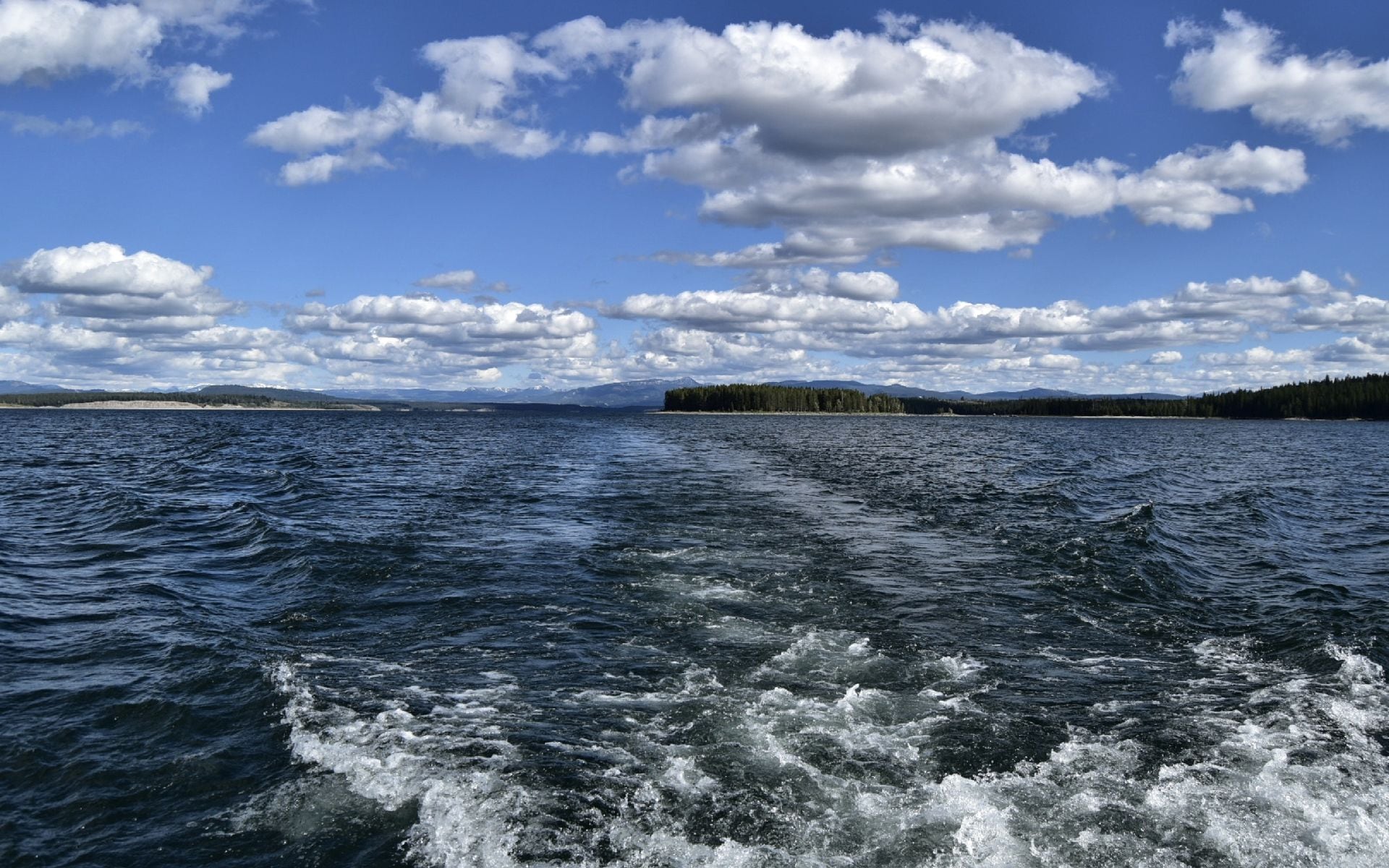 Sailboats on Flathead Lake with the Mission Mountains reflected in calm blue water, northwest Montana